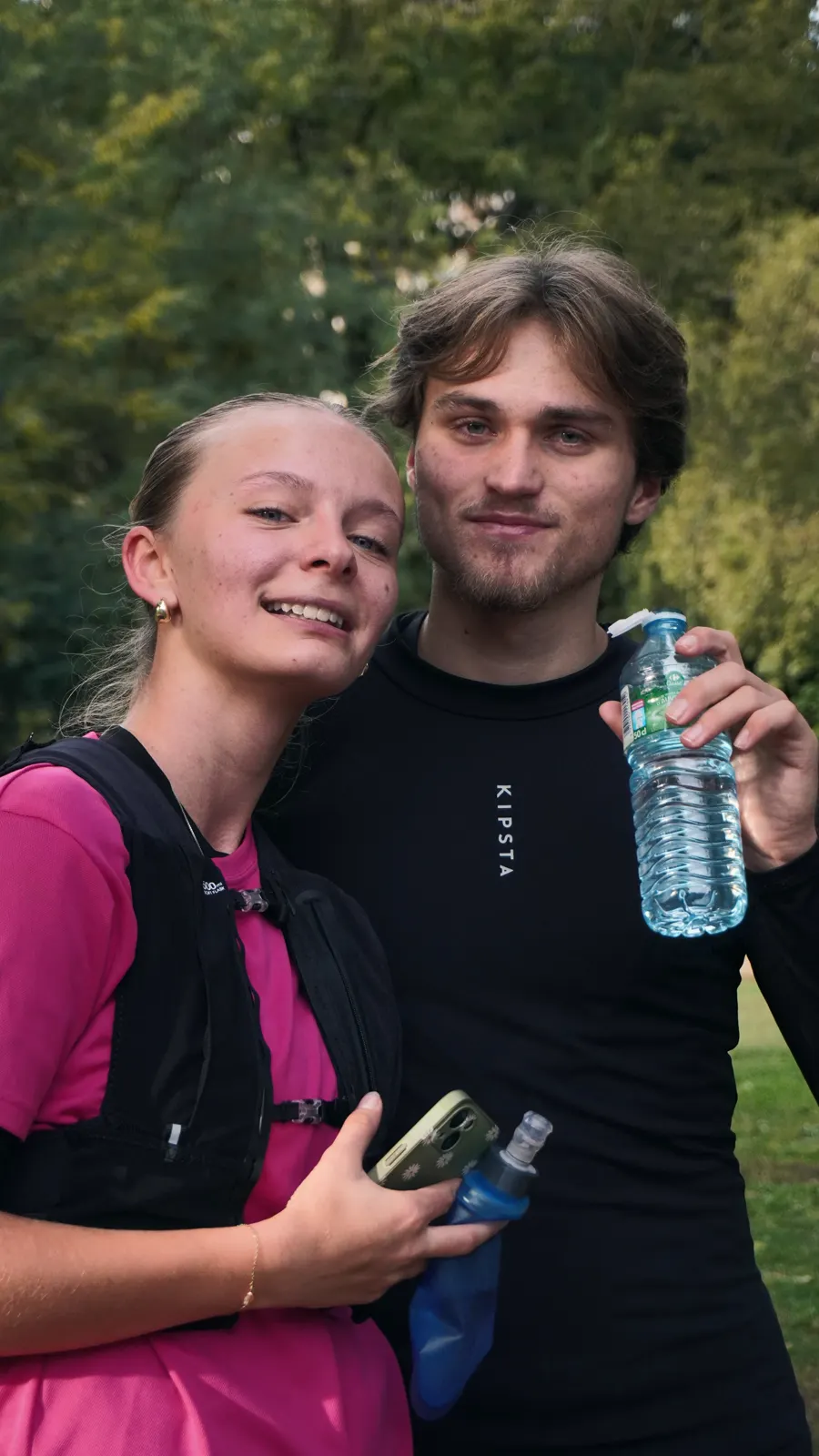 Deux membres du club posent ensemble, bouteille d’eau à la main