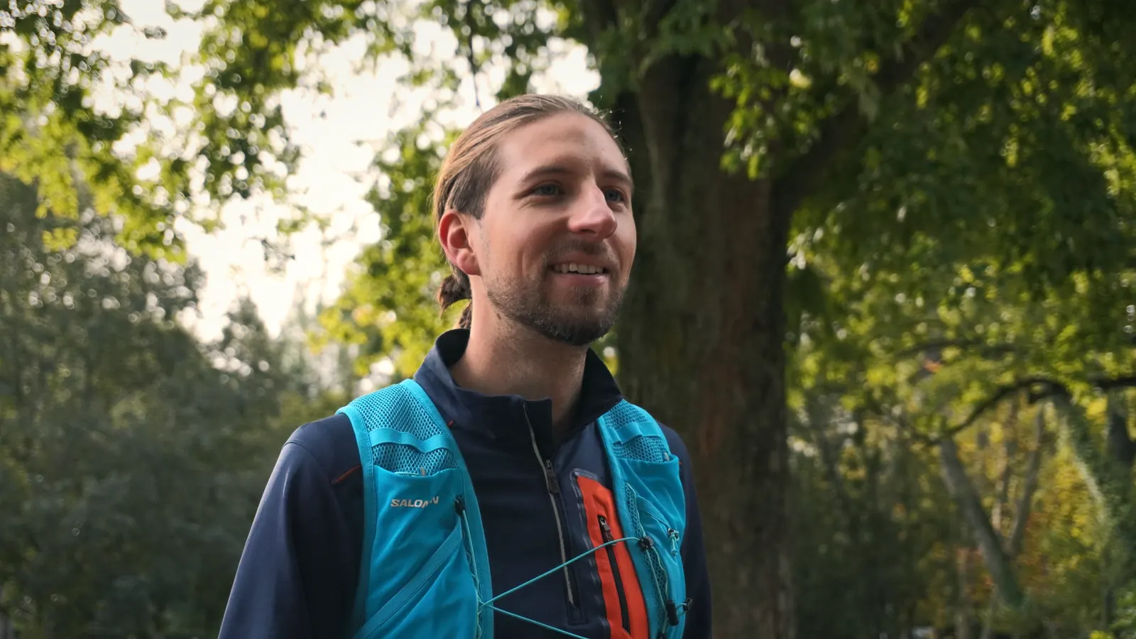 Un coureur en gilet bleu profite de l’après-run sous les arbres