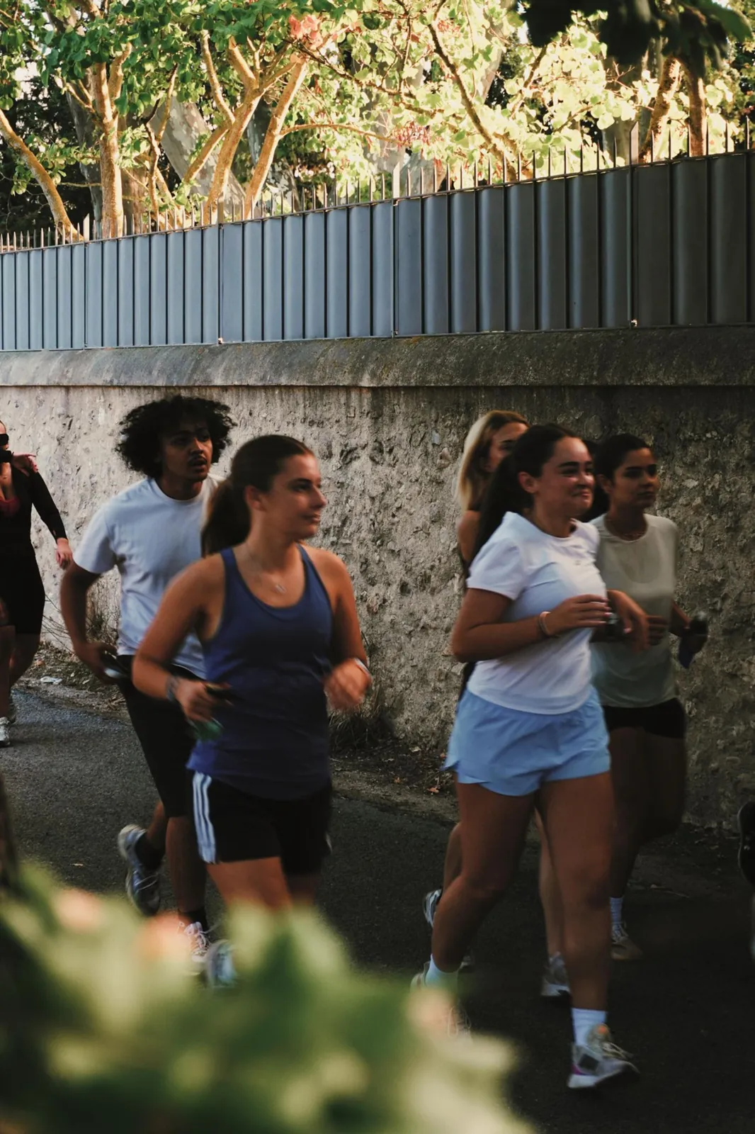 Des coureuses et coureurs du club le long d’un mur, en pleine sortie