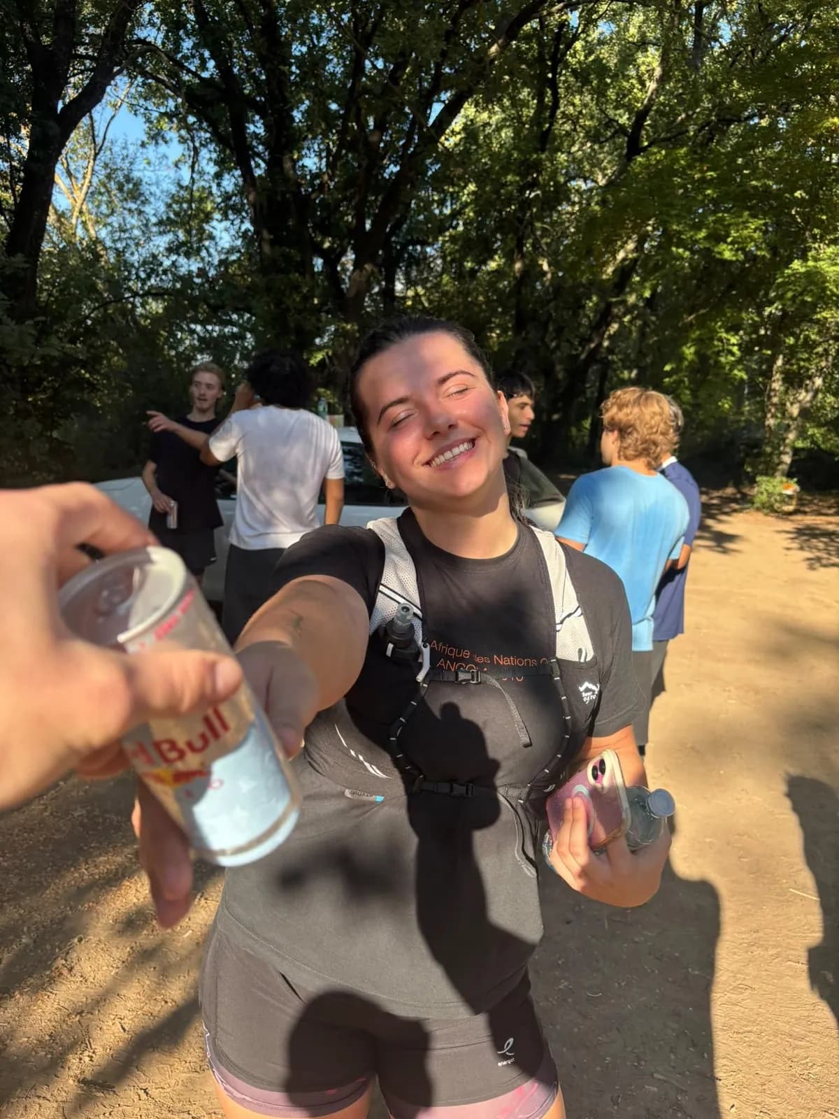 Un coureur souriant reçoit une canette après la sortie