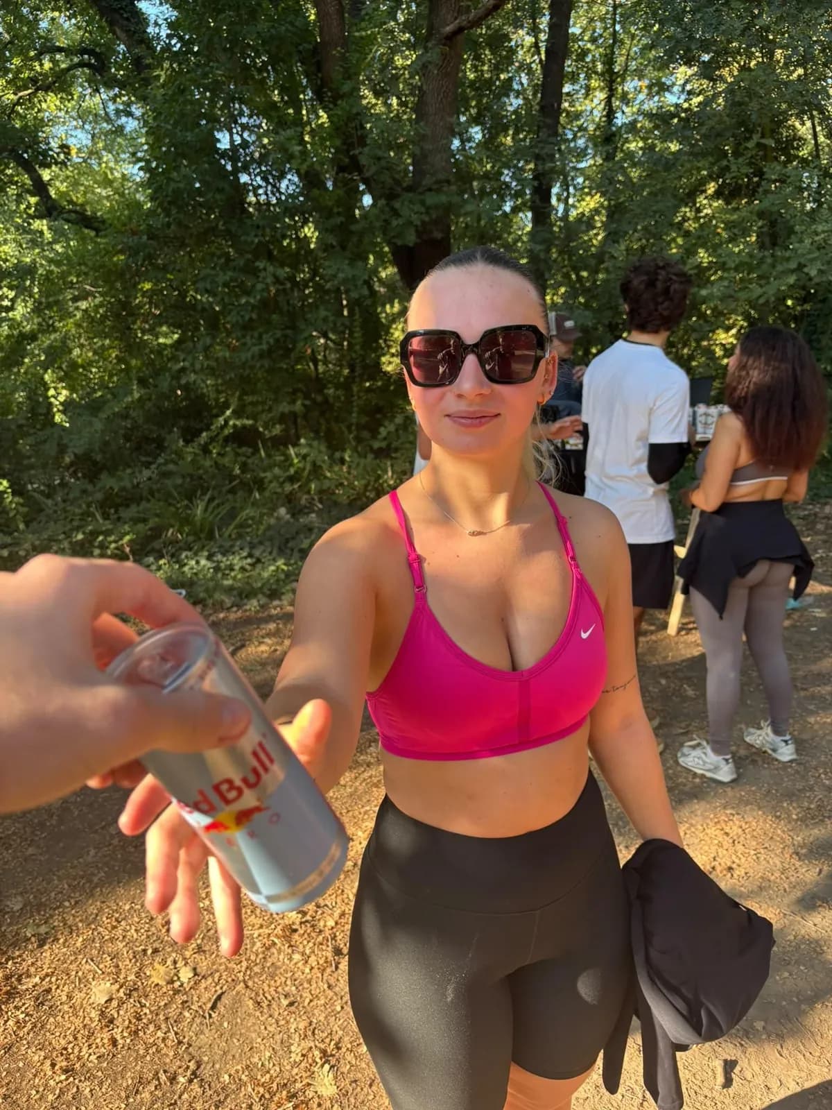 Une coureuse en lunettes de soleil attrape une Red Bull